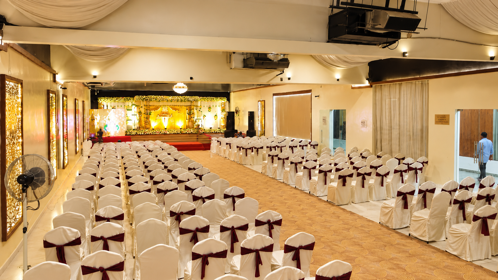 NS Convention main hall with rows of chairs facing a decorated wedding stage