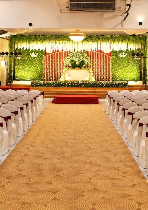 NS Convention main hall set for a wedding with chair rows and a green floral stage
